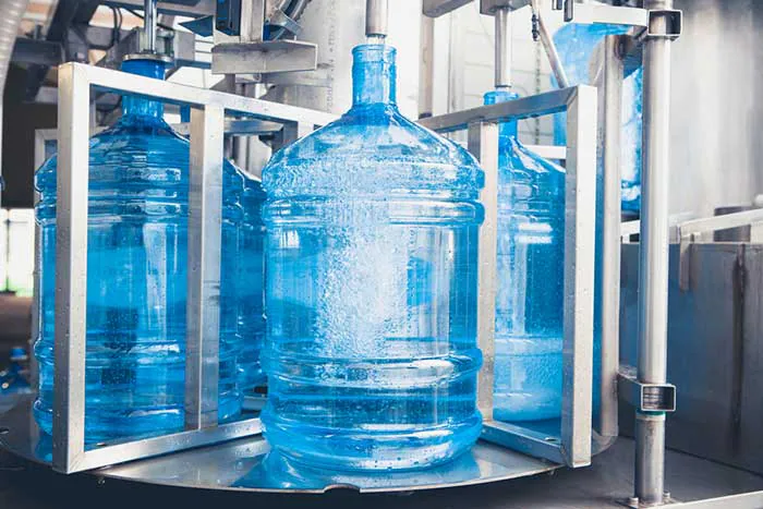 5 gallon water barrels on a filling line conveyor